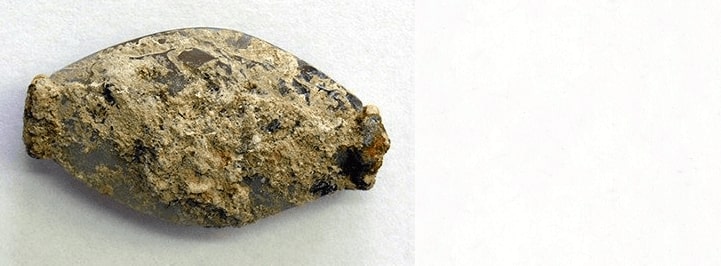 Pylos Combat Agate ilk başta pek görünmüyordu. Sadece 3,6 santimetre (1,4 inç) uzunluğunda, bir kireçtaşı tabakasıyla kaplanmış küçük bir taş parçası. Fotoğraf: Cincinnati Üniversitesi, Klasikler Bölümü