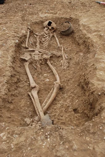Çanak çömlek kabı ve broşları ile gömülmüş erken bir Anglo-Sakson mezarı. Mezar, Oakington Cambridgeshire'dan 66 yaşındaki bir kişiye ait. © Duncan Sayer ·