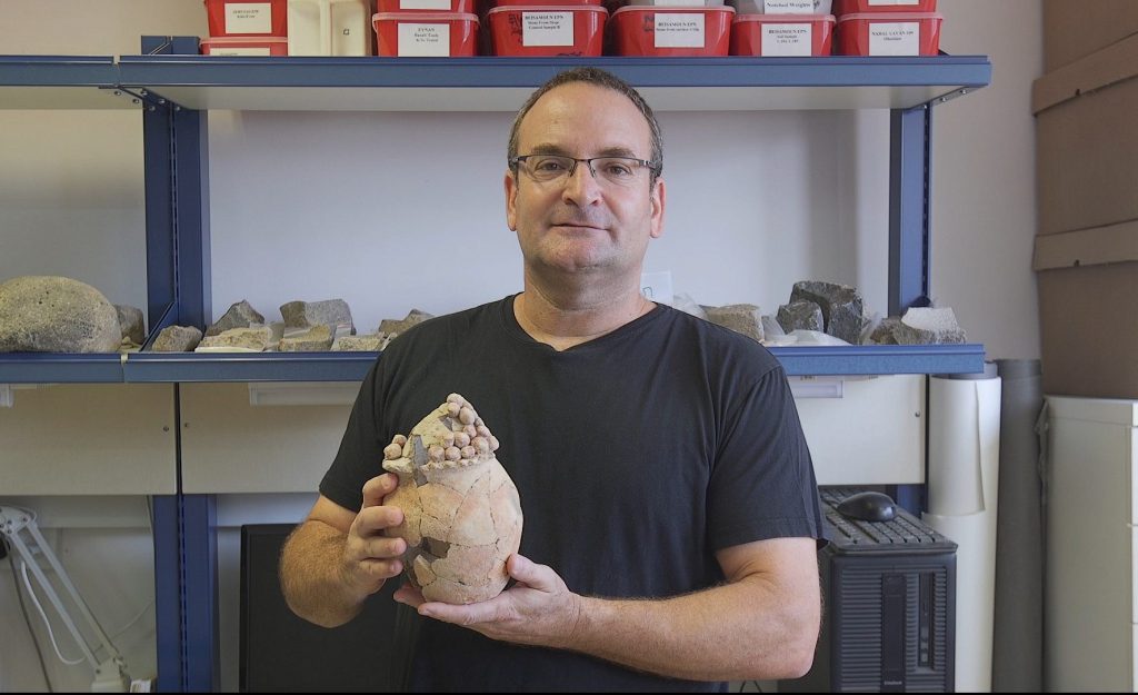 Haifa Üniversitesi Prof. Danny Rosenberg elinde Tel Tsaf'ta bulunan 7.200 yıllık kil tahıl çömleği (Hayfa Üniversitesi)